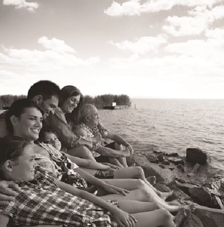 Happy family sitting on beach looking at sea