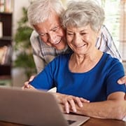 Elderly married couple looking at the computer
