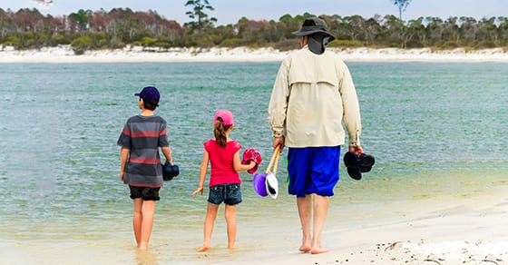 grandfather walking on beach with grandkids | taxes and retiring and moving to another state | Dalby Wendland & Co | CPAs | Business Advisors | Colorado