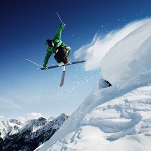 extreme skier doing a trick off high mountain