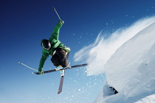 extreme skier jumping off ledge of snow