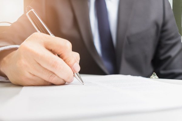 Close up of a business man signing documents