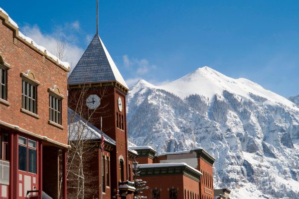 clock tower in downtown Telluride Colorado and snowy mountains in the background