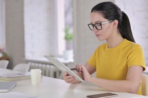 young female in conference room working on her tablet