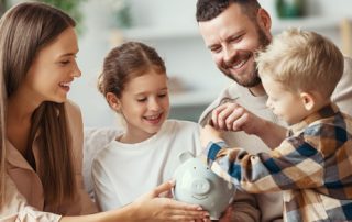 young family putting money into a piggy bank
