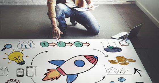 Budgeting Basics for Entrepreneurs  person kneeling over large visual graphic of a business plan made up of financial and planning icons | article, Budgeting Basics for Entrepreneurs | DWC CPAs and Advisors | business consulting, tax services, audit and assurance, estate and gift planning, wealth management, bookkeeping, outsourced accounting | Grand Junction CO | Montrose CO | Glenwood Springs CO