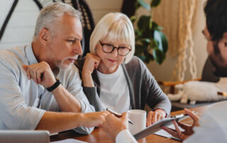 A middle aged couple looking at estate planning | a man with a paper showing them estate planning | making a decision to proceed | DWC CPAs and Advisors | business consulting, tax services, audit and assurance, estate and gift planning, wealth management, bookkeeping, outsourced accounting | Grand Junction CO | Montrose CO | Glenwood Springs CO