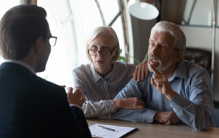 An older couple meeting with a professional advisor to discuss estate planning and legal decisions.