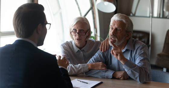 An older couple meeting with a professional advisor to discuss estate planning and legal decisions.