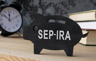 Wooden piggy bank with SEP IRA inscription on the side.