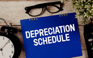 Depreciation Schedule text with alarm clock and calculator on wooden background