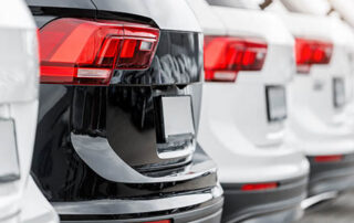 Back view many modern new SUV cars fleet stock at dealership parking lot. Automobile market production factory industry warehouse.