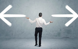 A businessman in doubt, having to shoose between two different choices indicated by arrows pointing in opposite direction concept