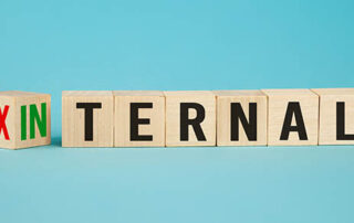 External and internal on wooden cubes, dice or blocks showing the words external and internal on blue background.