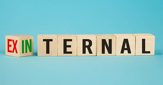 External and internal on wooden cubes, dice or blocks showing the words external and internal on blue background.
