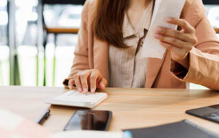young woman hand checking list with bill for calculate accounting expense credit card payment on due deadline, trying to find money to pay debt on table. Business financial concept,